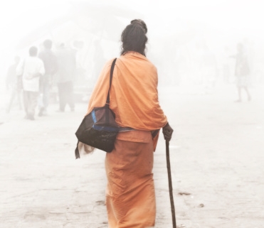 indian sadhu is walking trough the mist in varanasi india